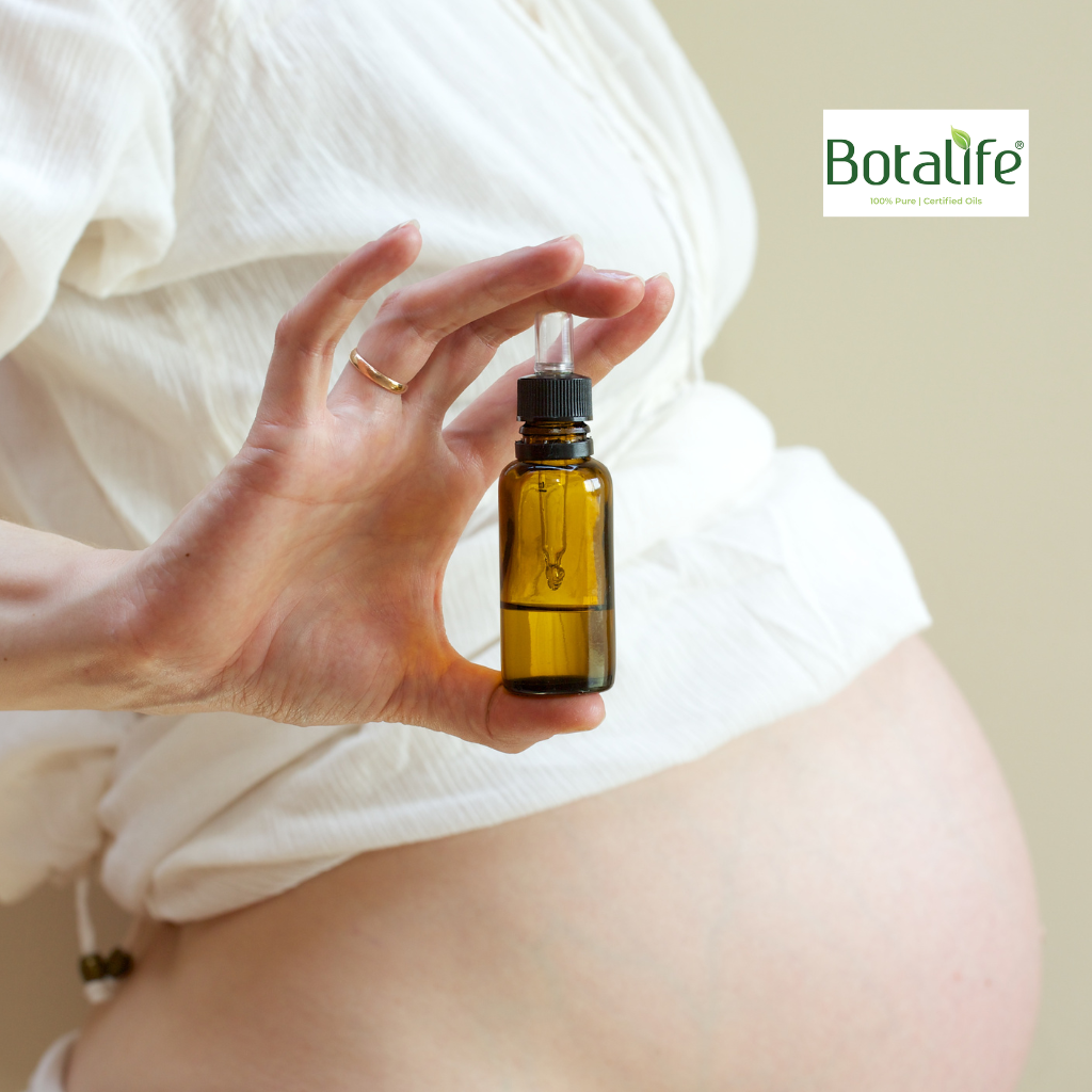 От бременността до майчинството: бременна жена държи етерично масло в стъклена капкомерна бутилка, BOTALIFE, масло от черен кимьон, дифузер, арома терапия